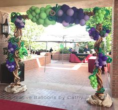 an archway decorated with balloons and vines