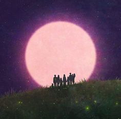 a group of people standing on top of a grass covered hill under a full moon