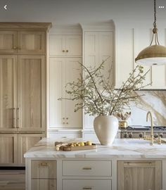 a large kitchen with marble counter tops and wooden cabinetry, along with a vase filled with flowers