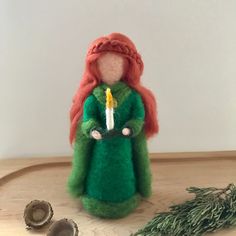 a doll with a candle in her hand and some other items on the table next to it