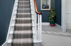 the stairs are painted blue and white with chevron patterns on them, along with a potted plant