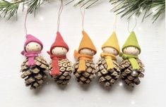 three little gnomes are hanging from pine cones