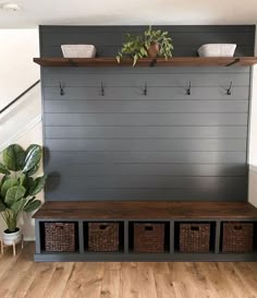 an entryway bench with baskets and plants on the top shelf, along with two planters