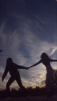 two people are holding hands as the sun sets in the sky behind them and there is no image on this page to describe