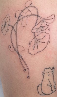 a tattoo on the back of a woman's shoulder with an image of a bear and flowers