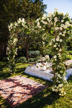 an outdoor ceremony setup with white flowers and greenery