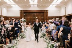 a bride and groom walking down the aisle