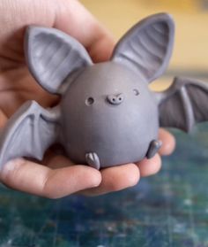 a person holding a gray toy bat in their hand