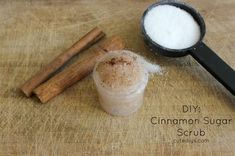 cinnamon sugar scrub in a cup next to cinnamon sticks