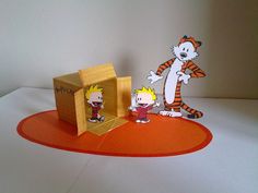 an orange and white paper cut out of a cartoon character with a cat in a box