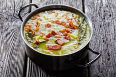 a pot filled with soup sitting on top of a wooden table