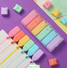 pastel colored stationery with bear shaped erasers on purple surface next to other stationery items