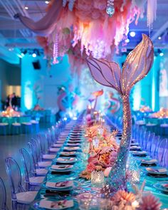 a long table is set with plates and place settings for an elegant dinner party in blue hues