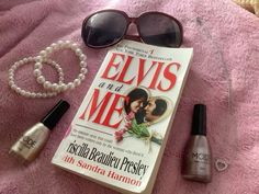 the book elvis and me is laying on a bed next to some nail polish, sunglasses, and bracelet