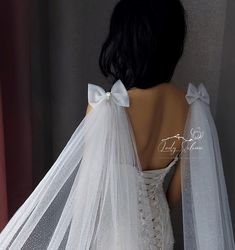 the back of a woman's wedding dress with a white bow on it