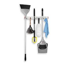 a wall mounted rack with brooms and cleaning supplies