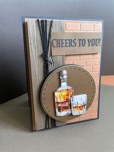 a card with a bottle of whiskey and two shot glasses on the front that says cheers to you