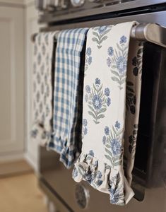 kitchen towels hanging on an oven door with blue flowers and gingham checkered fabric