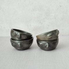 two metal bowls sitting next to each other on a table