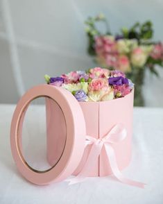 a pink box with flowers in it on a table