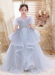 Bring a touch of magic to your special day with our enchanting Crystal Blue Flower Girl Dress. This exquisite gown features a dreamy, layered tulle skirt adorned with delicate snowflake patterns that shimmer with every movement. The bodice is beautifully embellished with intricate floral appliques and sparkling sequins, creating a look that is both whimsical and elegant. Soft, puffed sleeves and a charming, ruffled neckline add to the fairy-tale appeal of this dress. Perfect for any elegant, bohemian, or traditional wedding theme, this dress ensures your flower girl will radiate pure charm and grace. Whether she's leading the bride down the aisle or dancing the night away, she'll feel like a princess in this breathtaking gown. Elevate her role on your special day with this effortlessly bea Snowflake Theme Dress, Pageant Wardrobe, Sequin Flower Girl Dress, Plus Size Prom Dress, Flower Girl Dresses Blue, Tulle Embroidery, Princess Flower Girl Dresses, Princess Flower, Green Tulle