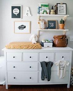 a baby's room with white dressers and pictures on the wall above it