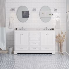 a white bathroom with two sinks and mirrors