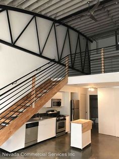 an open floor plan with stairs leading up to the kitchen and living room in this loft apartment