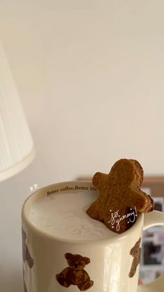 a coffee mug with a teddy bear on the inside and bottom, sitting on a table next to a lamp