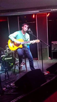 a man is playing guitar on stage