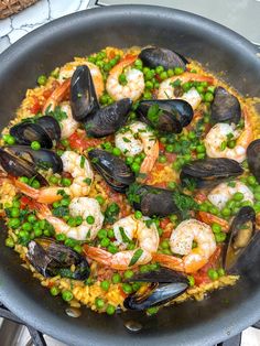 a pan filled with seafood and rice on top of a stove