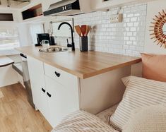 a kitchen area with sink, stove and counter top in a trailer or camper