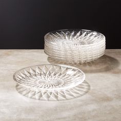 two clear glass dishes sitting on top of a white countertop next to each other