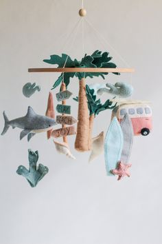 a mobile made out of felt with animals and trees hanging from it