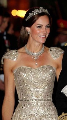 the duke and princess of cambridge smile as they walk down the red carpet at an event