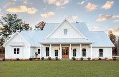 a white house sitting on top of a lush green field