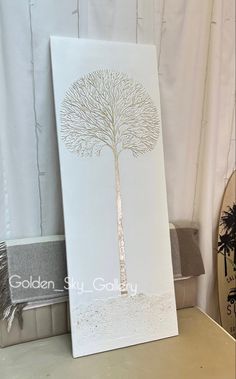 a white card with a gold tree on it