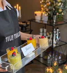 a person holding a tray with desserts on it