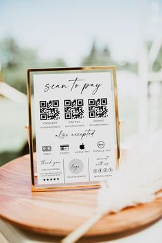 a close up of a sign on a table with a white feather in front of it