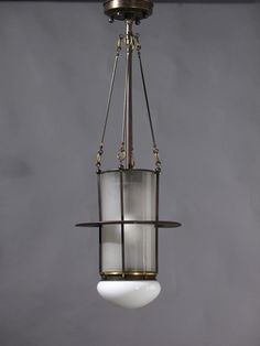 a light fixture hanging from the ceiling in a room with gray walls and flooring