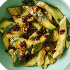 a blue bowl filled with cucumber and raisins