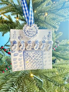 a christmas ornament hanging from a tree with blue and white ornaments on it