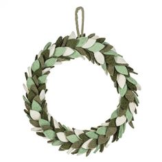 a green and white wreath with leaves on it's sides, hanging from a cord