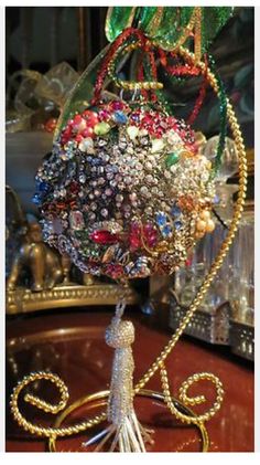 a close up of a bunch of brooches on a metal stand in front of a mirror