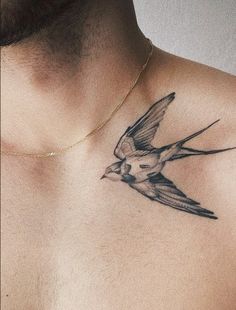 a man's chest with a bird tattoo on his chest and the back of his neck