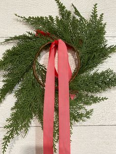 a wreath with pink ribbon hanging from it