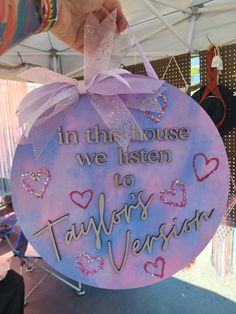 someone holding up a sign that says in this house we listen to taylors version