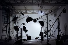 a photo studio with lights and equipment in the dark, lit up by spotlights