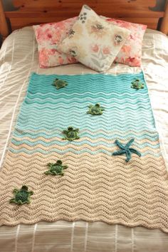 a crocheted blanket on top of a bed with sea turtles and starfish