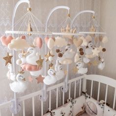 a baby crib with some stuffed animals hanging from it's sides and stars on the ceiling